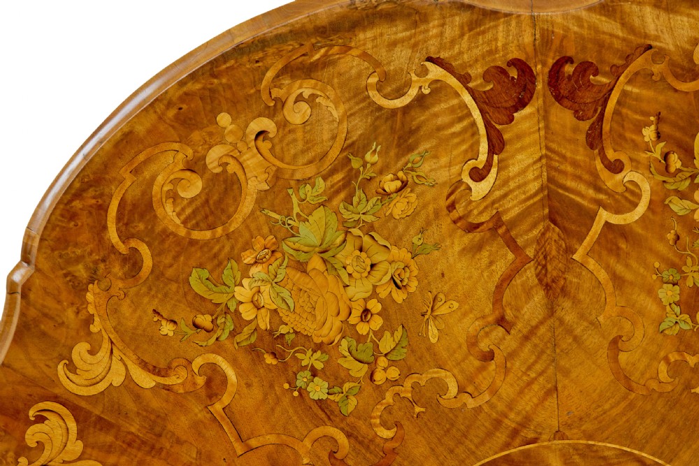 A 19th-century Victorian walnut centre table featuring intricate floral marquetry inlays, a shaped rim, and a carved central pedestal with four scroll legs on castors. View XI