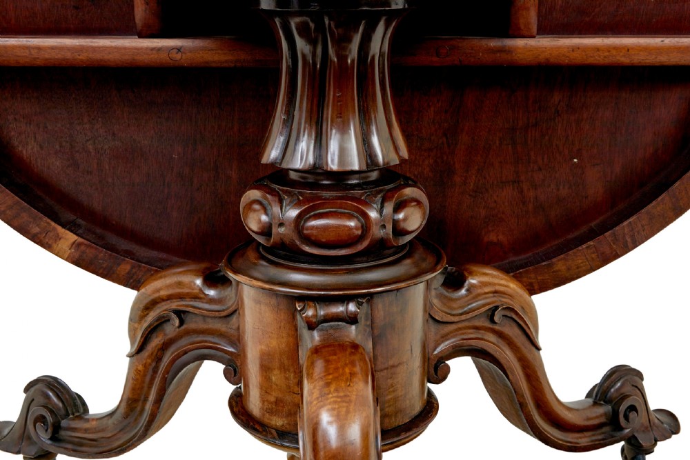A 19th-century Victorian walnut centre table featuring intricate floral marquetry inlays, a shaped rim, and a carved central pedestal with four scroll legs on castors. View XIII