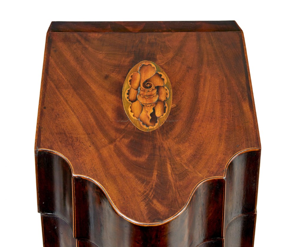 An 18th-century Georgian mahogany knife box featuring a sloping lid with a central floral marquetry inlay, serpentine front profile, and brass keyhole escutcheon. View VI
