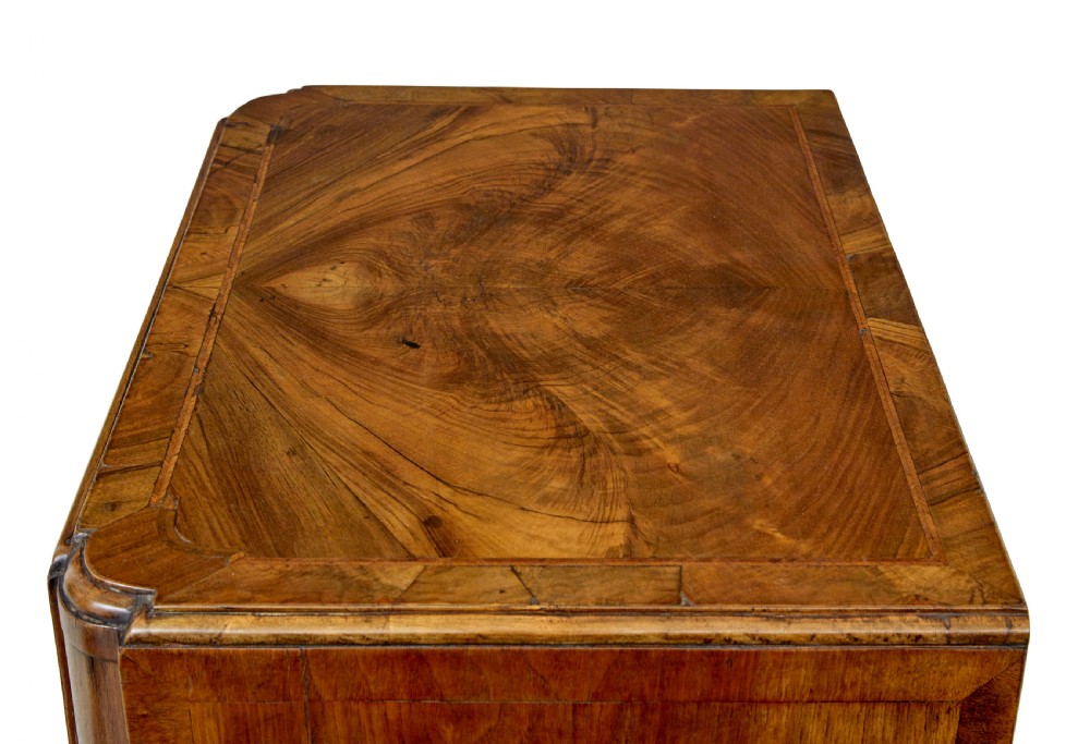 A four-drawer walnut chest featuring figured wood veneers, shaped bottom apron, brass handles, and rounded front corners. View II
