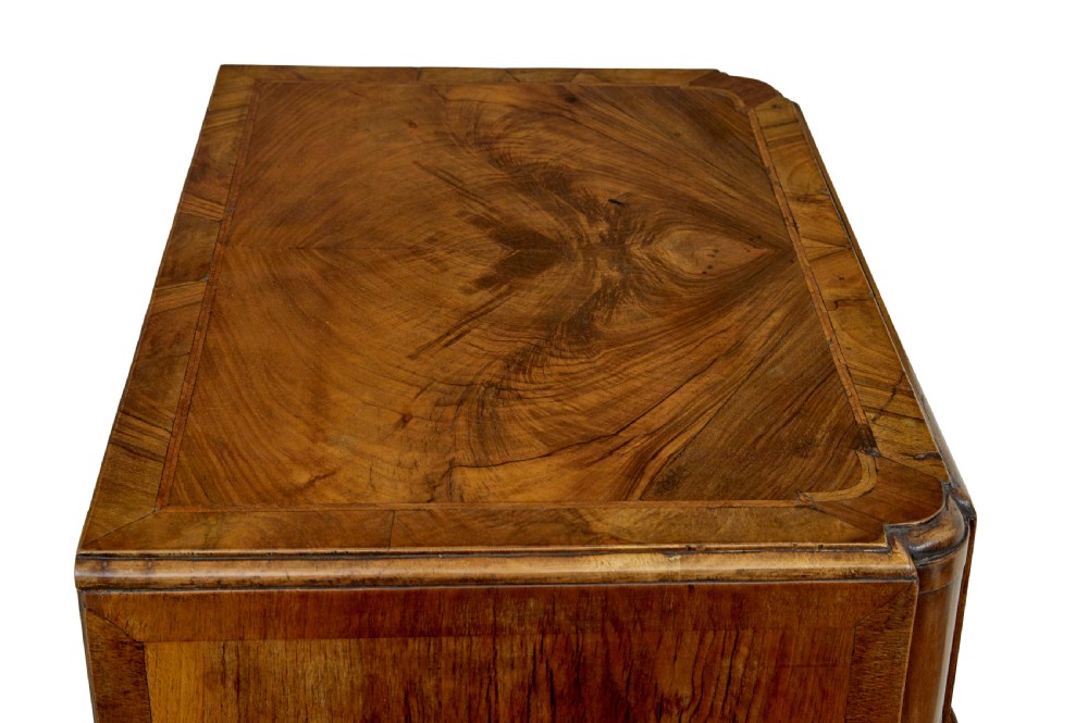 A four-drawer walnut chest featuring figured wood veneers, shaped bottom apron, brass handles, and rounded front corners. View III