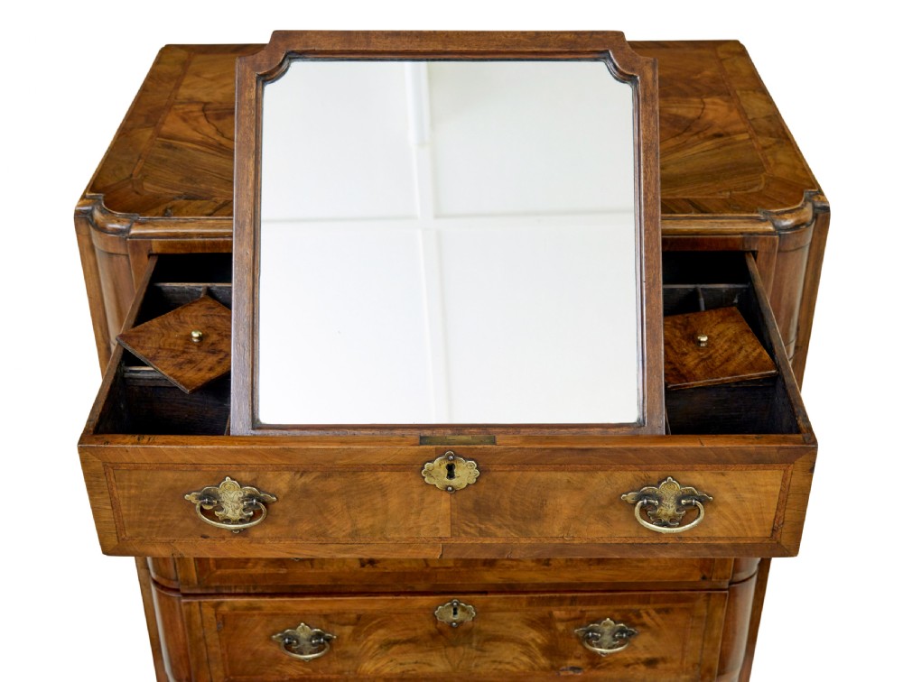 A four-drawer walnut chest featuring figured wood veneers, shaped bottom apron, brass handles, and rounded front corners. View VII