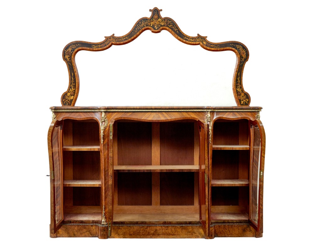 A High Victorian burr walnut credenza featuring floral marquetry inlay, glazed side display cabinets, gilt metal mounts, and a shaped mirror frame superstructure. View II