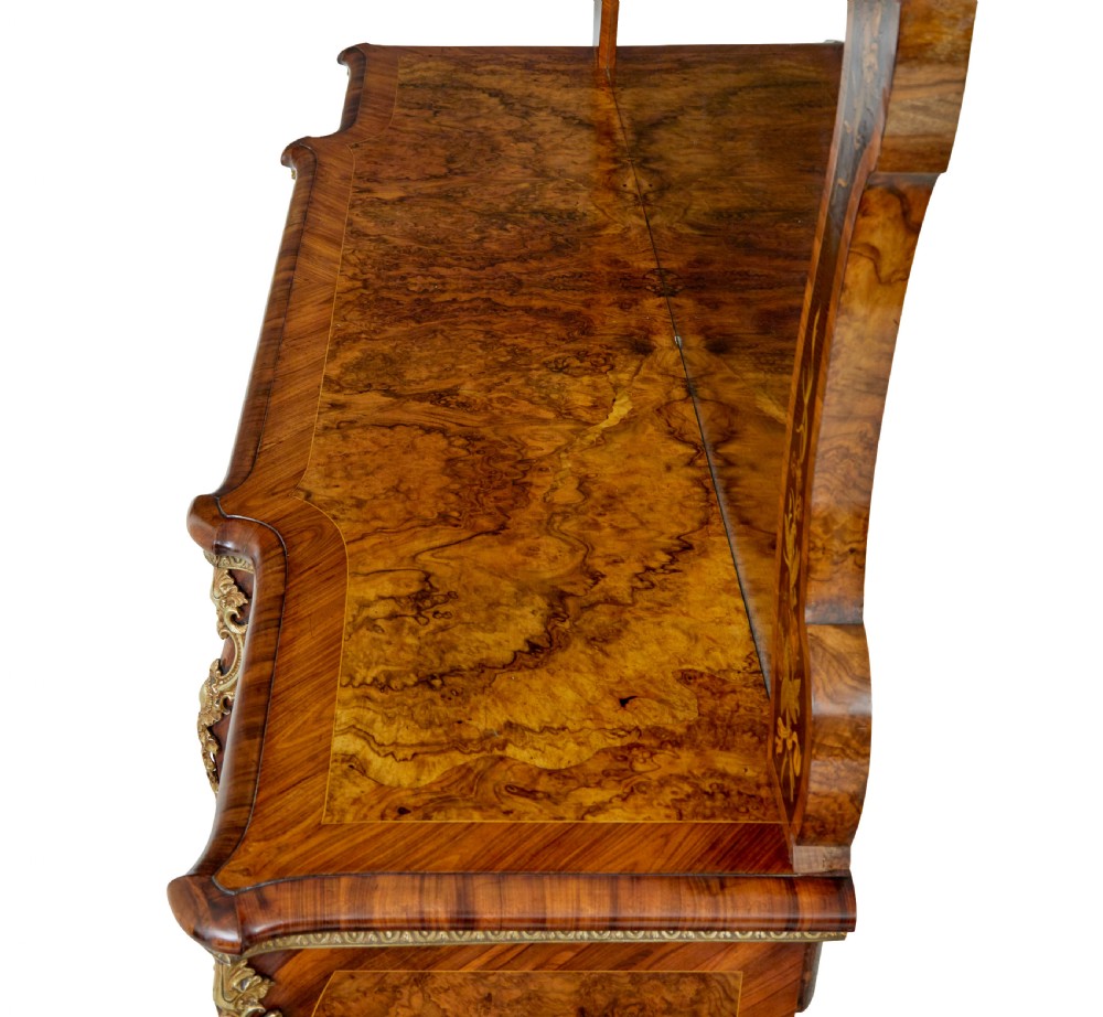 A High Victorian burr walnut credenza featuring floral marquetry inlay, glazed side display cabinets, gilt metal mounts, and a shaped mirror frame superstructure. View X