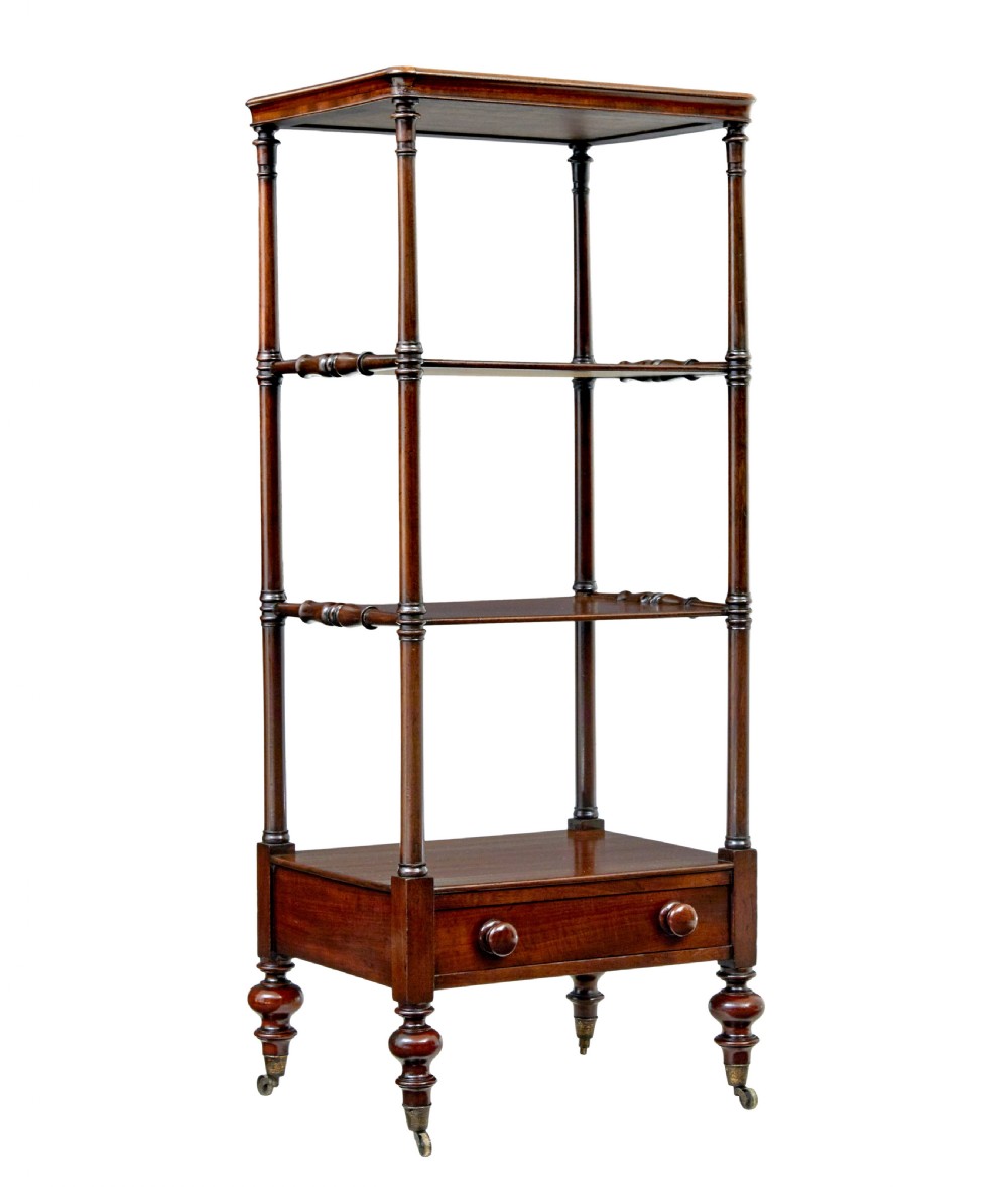 A mid-19th-century mahogany four-tier whatnot featuring slender turned supports, a single base drawer with turned wooden handles, and turned legs with brass castors.