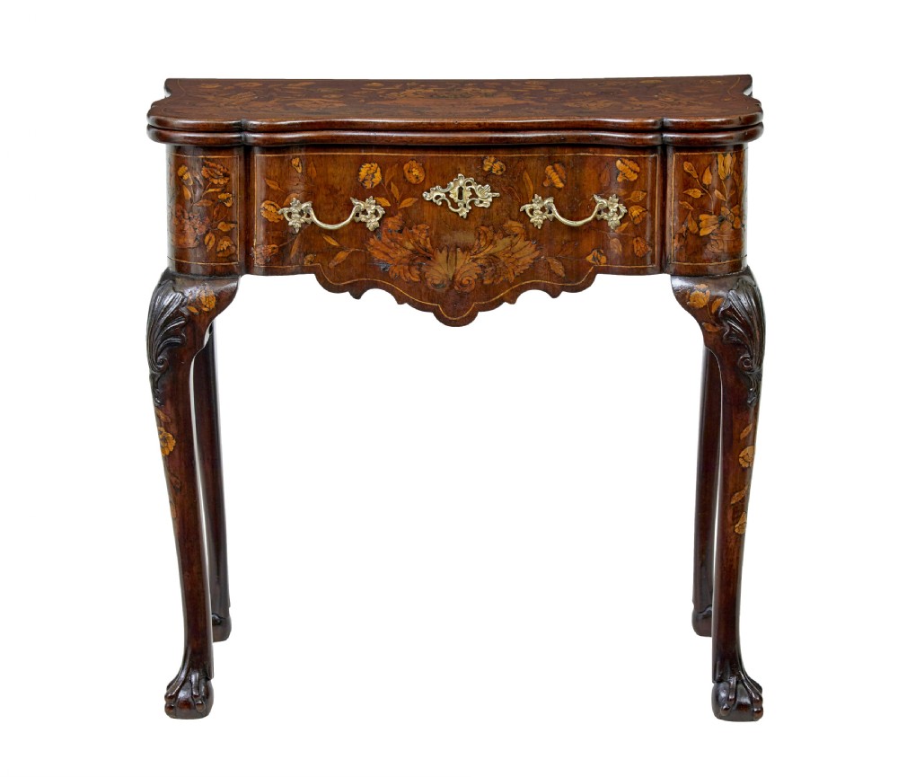 An 18th-century Dutch walnut games table decorated with floral marquetry inlay, carved cabriole legs, and brass drop handles.