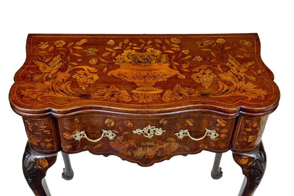 An 18th-century Dutch walnut games table decorated with floral marquetry inlay, carved cabriole legs, and brass drop handles. View X