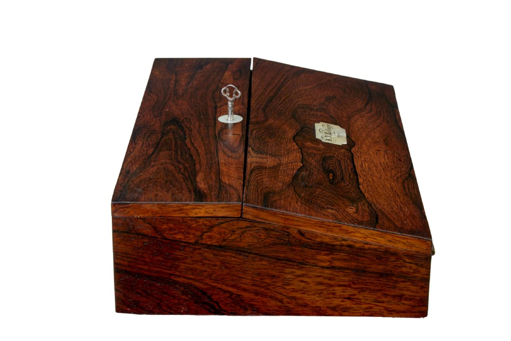 A 19th-century William IV figured rosewood writing slope featuring a slanted top, metal key, and an inlaid plaque dated 1835. View VI