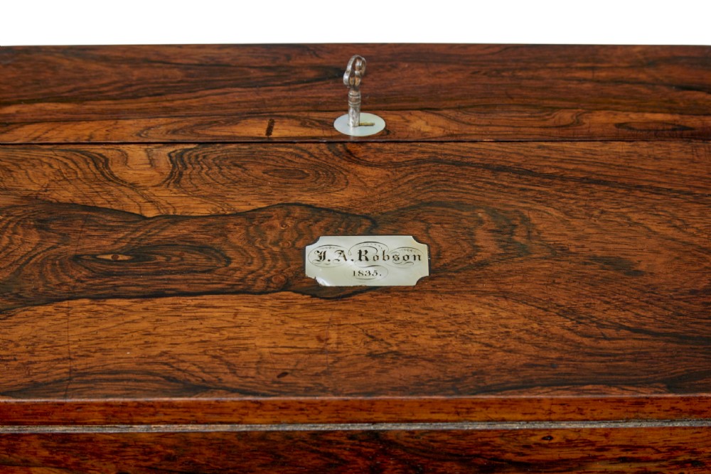 A 19th-century William IV figured rosewood writing slope featuring a slanted top, metal key, and an inlaid plaque dated 1835. View IX