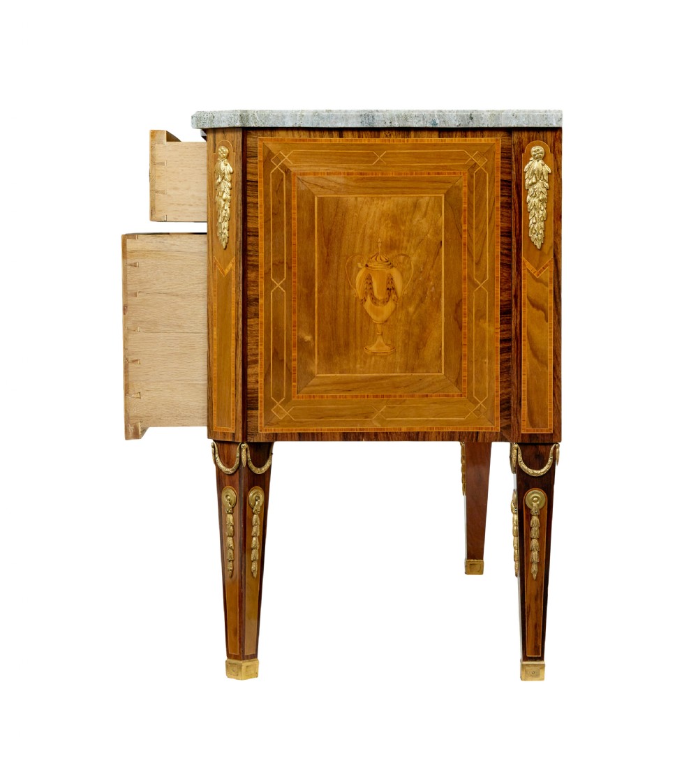 An early 20th-century walnut commode featuring marquetry inlay, gilt bronze mounts, square tapered legs, and a fitted grey marble top. View IV