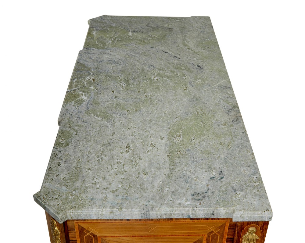 An early 20th-century walnut commode featuring marquetry inlay, gilt bronze mounts, square tapered legs, and a fitted grey marble top. View XI