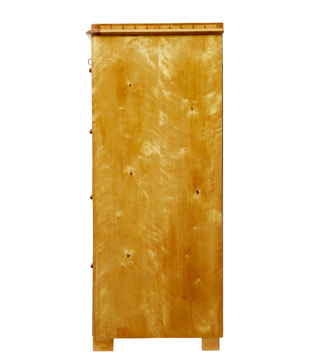 A 19th-century Swedish flame birch chest featuring five graduated drawers with white keyhole escutcheons. View V