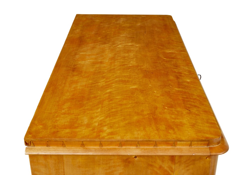 A 19th-century Swedish flame birch chest featuring five graduated drawers with white keyhole escutcheons. View VIII