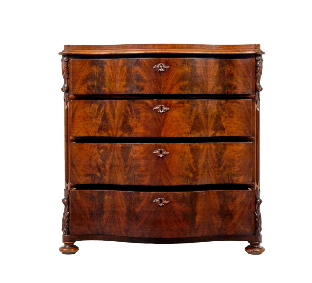 A 19th-century Swedish mahogany chest of drawers with a serpentine front, four drawers, flame timber veneer, carved side accents, and turned feet. View III