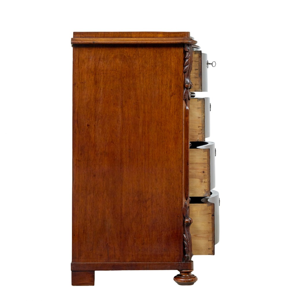 A 19th-century Swedish mahogany chest of drawers with a serpentine front, four drawers, flame timber veneer, carved side accents, and turned feet. View V