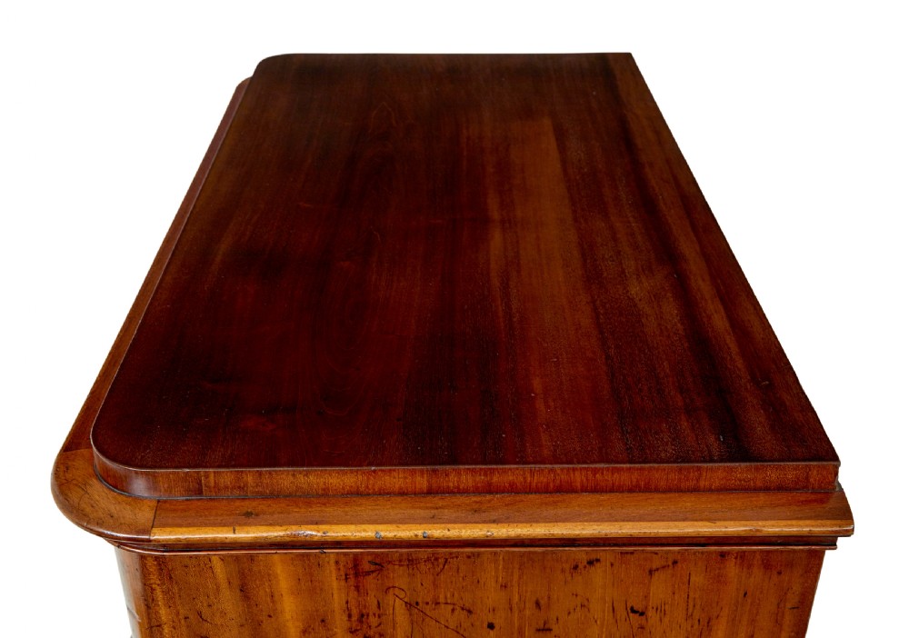A nineteenth-century Swedish mahogany chest of drawers featuring five stacked drawers with book-matched veneer and brass keyhole escutcheons. View XI