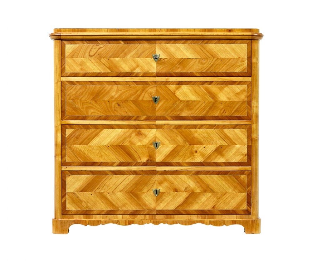 A mid-nineteenth-century Scandinavian chest of drawers crafted from inlaid elm wood with chevron patterns across four drawers and brass shield keyhole escutcheons. View II