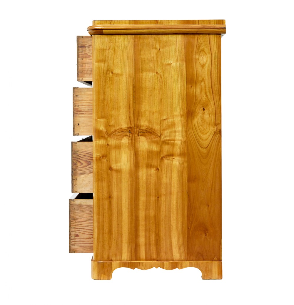 A mid-nineteenth-century Scandinavian chest of drawers crafted from inlaid elm wood with chevron patterns across four drawers and brass shield keyhole escutcheons. View V