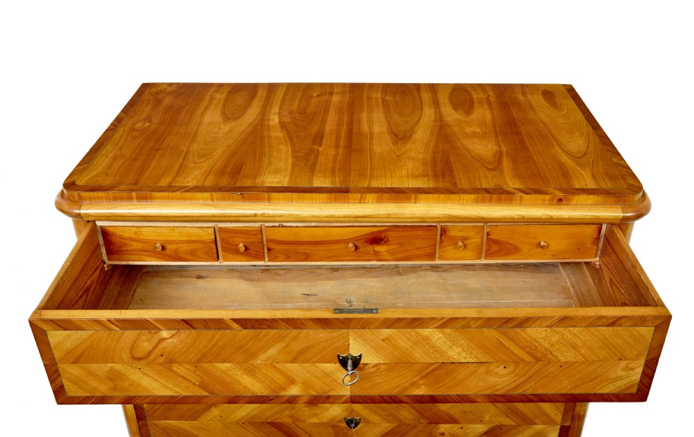 A mid-nineteenth-century Scandinavian chest of drawers crafted from inlaid elm wood with chevron patterns across four drawers and brass shield keyhole escutcheons. View XII