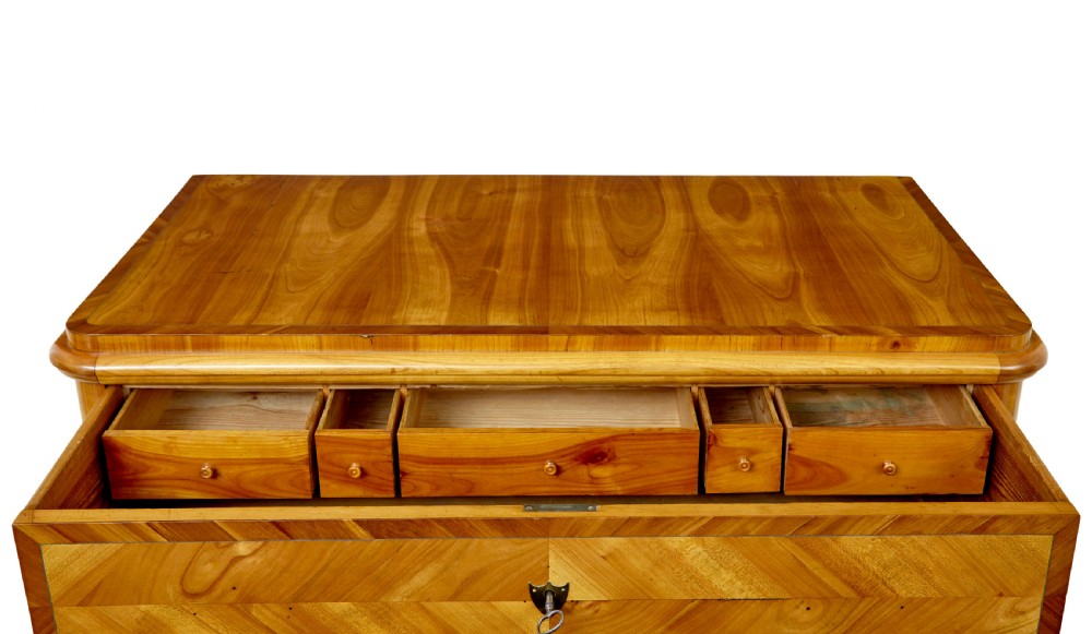 A mid-nineteenth-century Scandinavian chest of drawers crafted from inlaid elm wood with chevron patterns across four drawers and brass shield keyhole escutcheons. View XIV