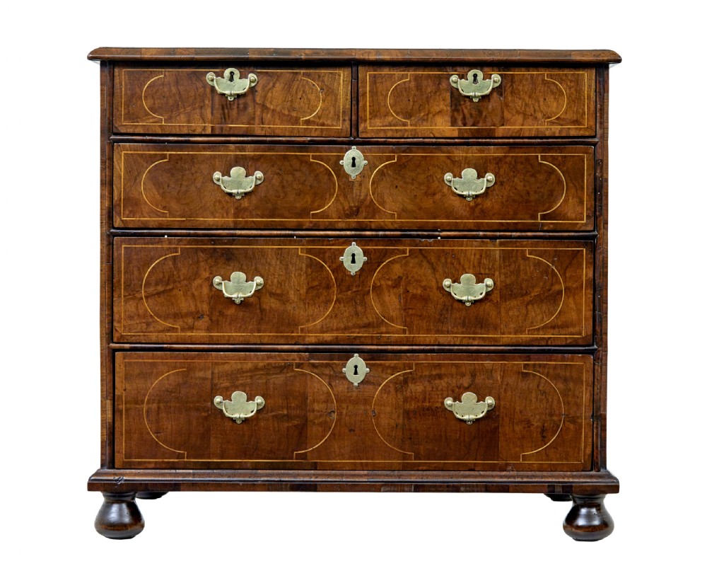 A 17th-century William and Mary walnut chest of drawers with decorative line inlay, brass drop handles, and turned bun feet. View II