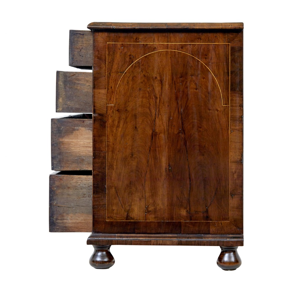 A 17th-century William and Mary walnut chest of drawers with decorative line inlay, brass drop handles, and turned bun feet. View V