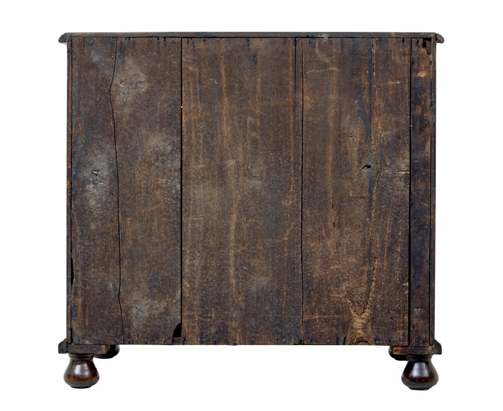 A 17th-century William and Mary walnut chest of drawers with decorative line inlay, brass drop handles, and turned bun feet. View VI