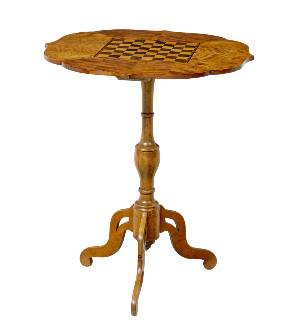 A 19th-century Swedish games table crafted from birch timber, featuring a lobed top with an inlaid wooden chessboard set upon a turned pedestal and tripod legs.