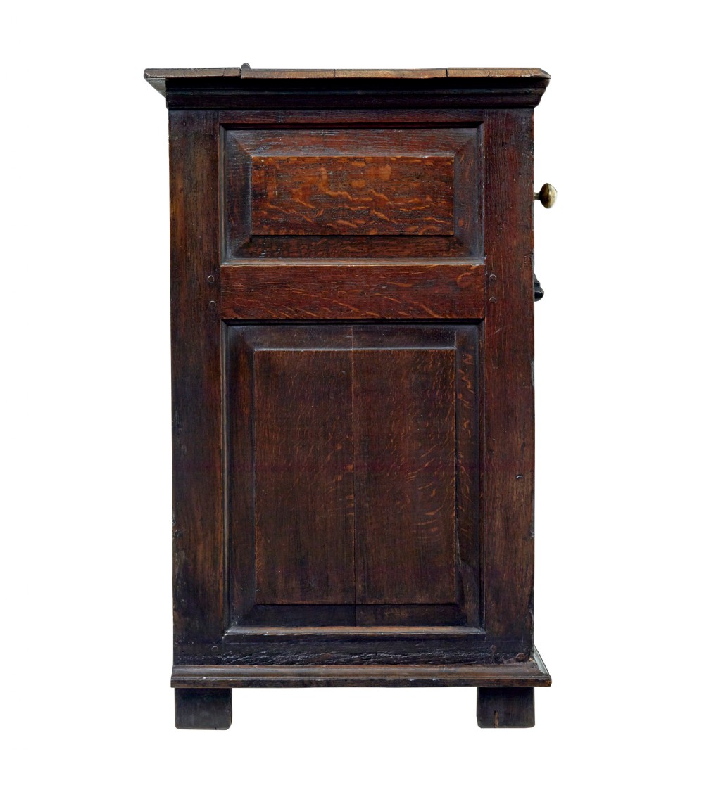 An 18th-century dark oak dresser featuring three geometric panelled drawers with brass knobs above cupboard doors with iron hinges. View VIII