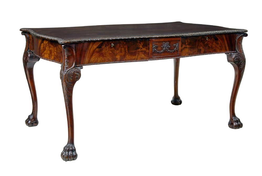 A mid-19th-century mahogany writing desk in the Chippendale style featuring cabriole legs ending in ball and claw feet, with carved knee details and frieze drawers.