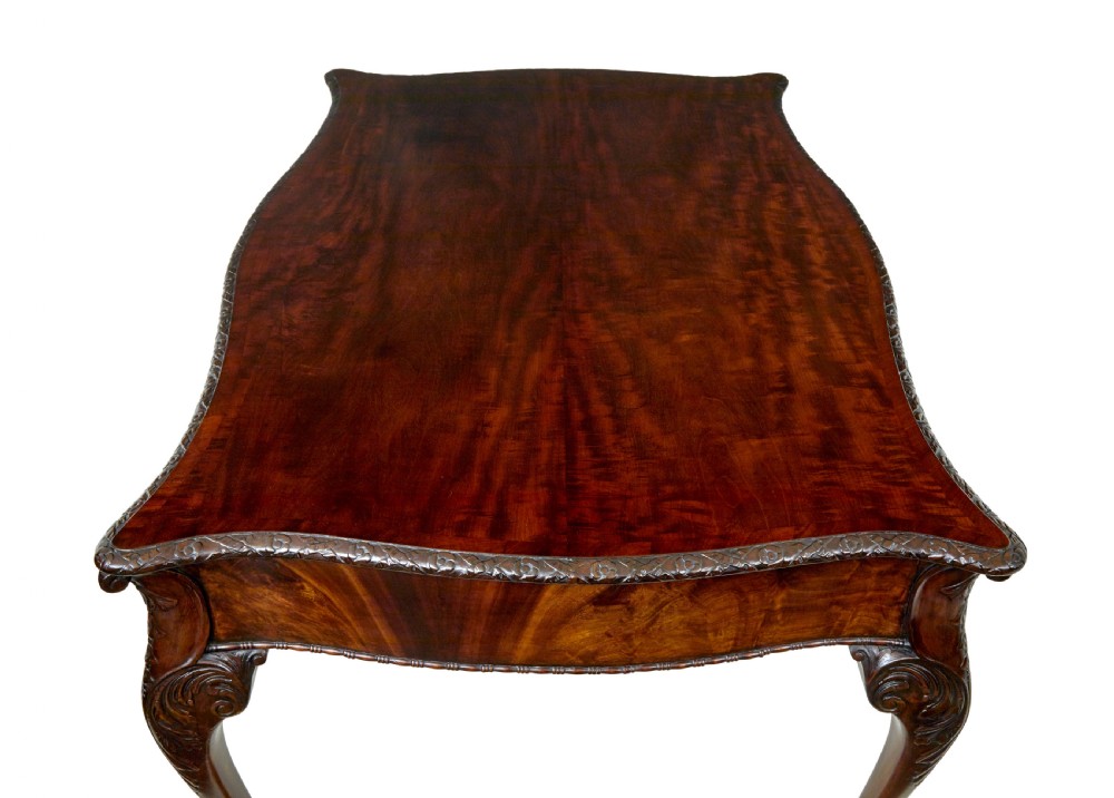 A mid-19th-century mahogany writing desk in the Chippendale style featuring cabriole legs ending in ball and claw feet, with carved knee details and frieze drawers. View XIV