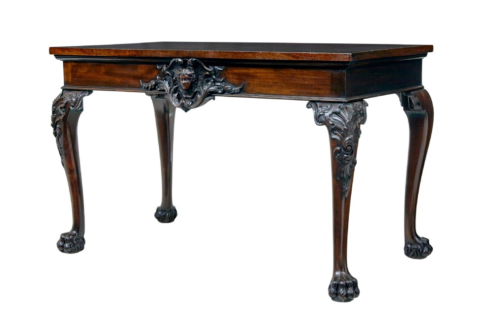 A 19th-century dark mahogany serving table featuring carved cabriole legs, claw feet, and a carved central apron mask.