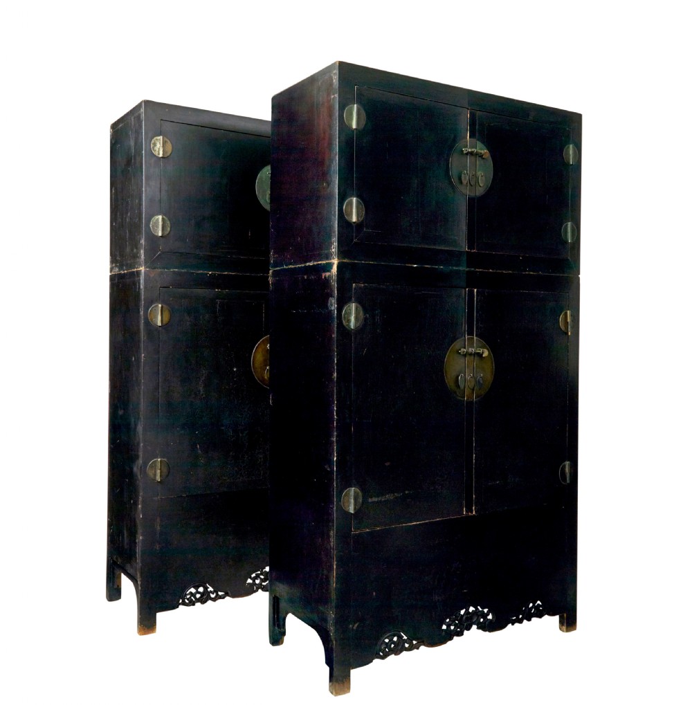 A pair of tall 19th-century black lacquered Chinese compound cabinets featuring circular brass lockplates and carved apron bases.