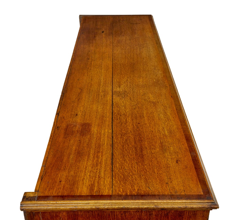 An 18th-century inlaid oak Lancashire dresser base featuring six drawers, a central two-door fielded panel cupboard, brass handles, and ogee bracket feet. View XI