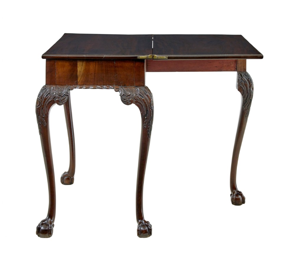 A 19th-century dark mahogany Chippendale Revival fold-over games table shown partially open, featuring carved cabriole legs and claw and ball feet.
