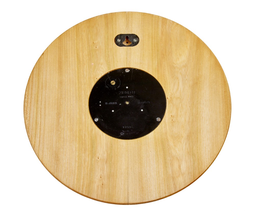 A circular Art Deco wall clock crafted from warm brown elm wood with applied brass numerals and hands. View VI
