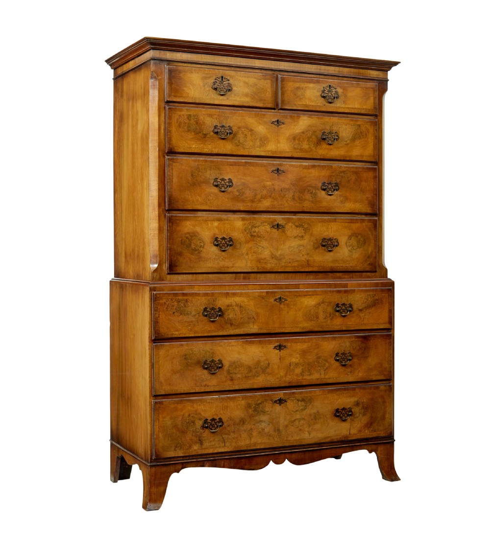 A two-section Late Georgian walnut chest on chest featuring figured timber veneers, brass drop handles, and bracket feet.