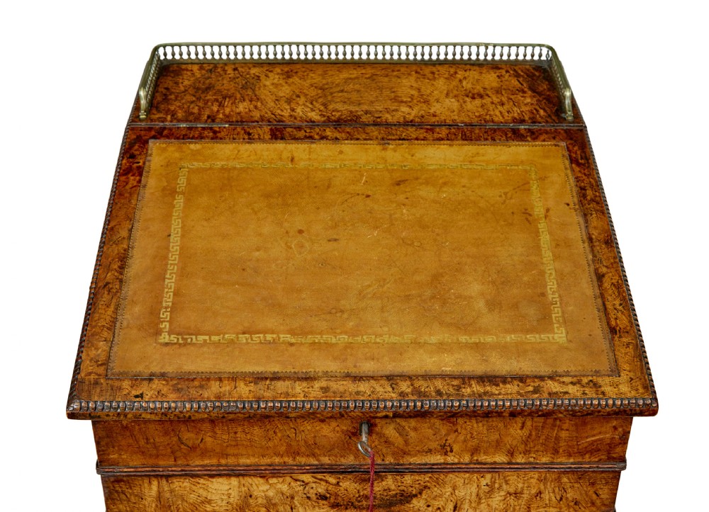 A mid-nineteenth century pollard oak Davenport desk featuring a sloped leather writing top with a brass gallery rail, side drawers with wooden knobs, and turned feet. View VIII