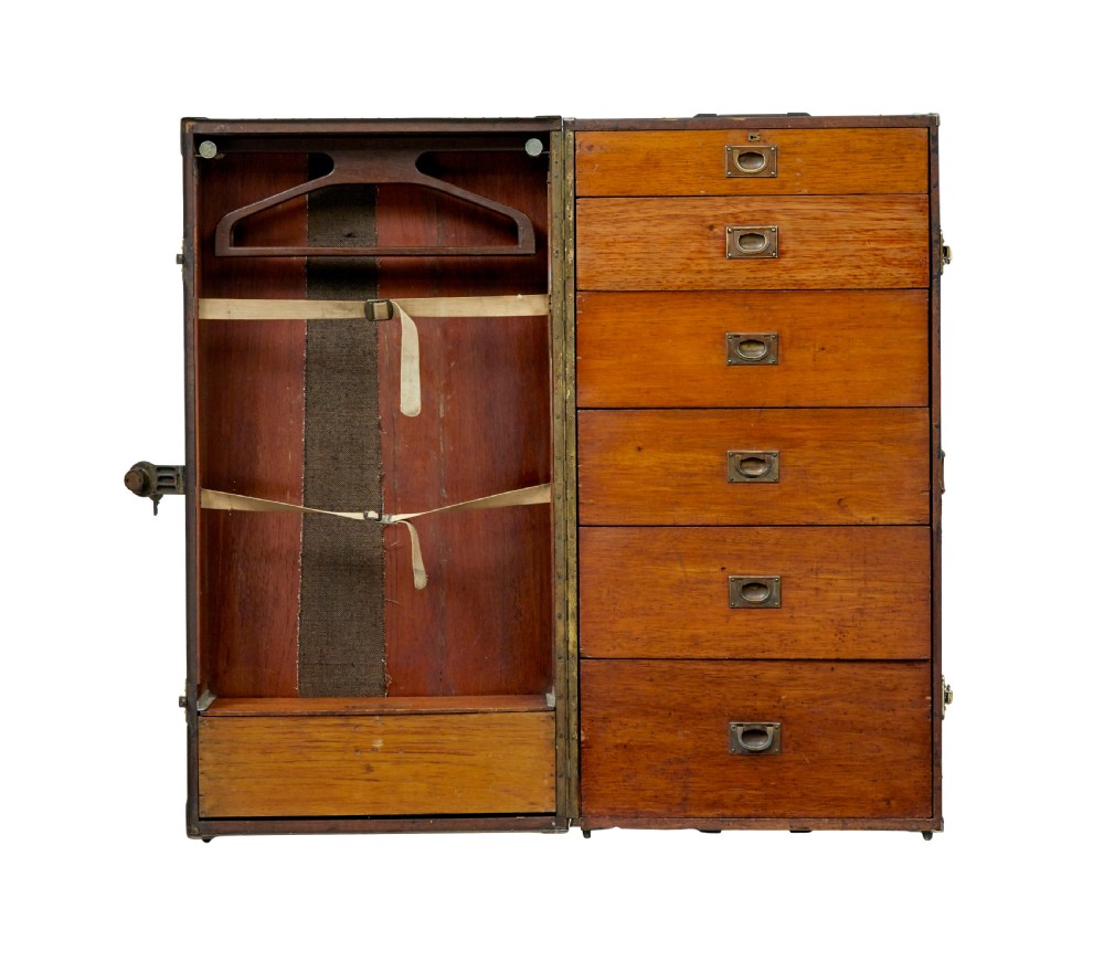 An open early 20th-century vertical steamer chest featuring a clothes hanging compartment with straps on the left and a column of six wooden drawers with recessed brass handles on the right. View III