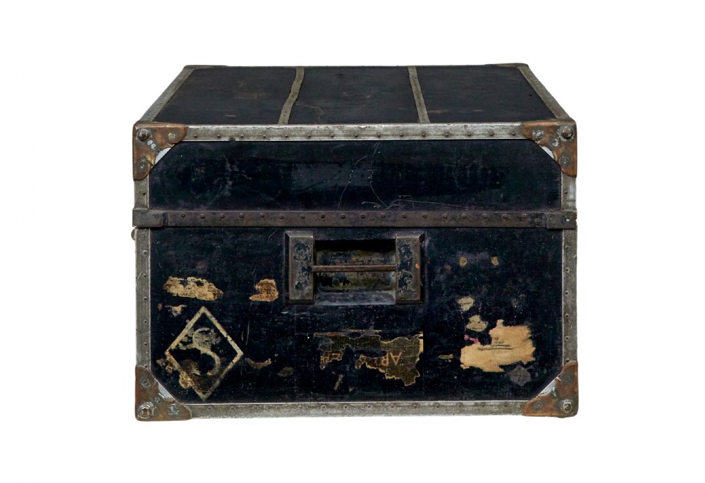 An open early 20th-century vertical steamer chest featuring a clothes hanging compartment with straps on the left and a column of six wooden drawers with recessed brass handles on the right. View VI