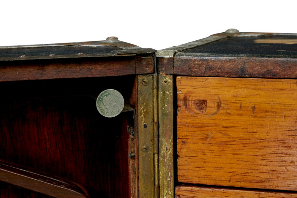 An open early 20th-century vertical steamer chest featuring a clothes hanging compartment with straps on the left and a column of six wooden drawers with recessed brass handles on the right. View X