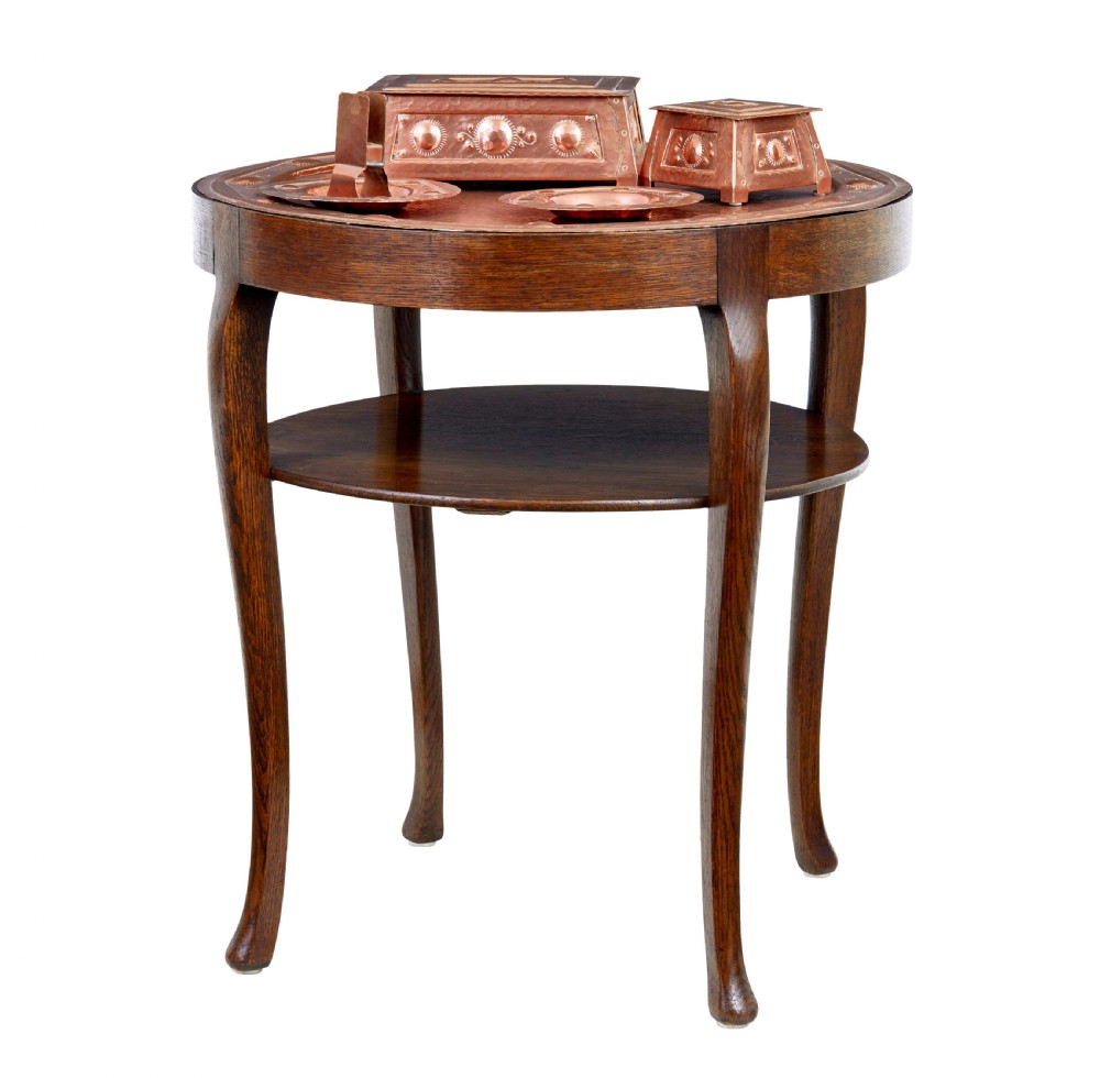 A late 19th-century Arts and Crafts circular oak occasional table featuring a central inset hammered copper tray top and a lower circular tier. View II
