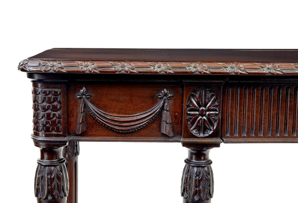 A 19th-century dark mahogany console table featuring a carved central urn, drapery swags, and six slender fluted legs. View VII