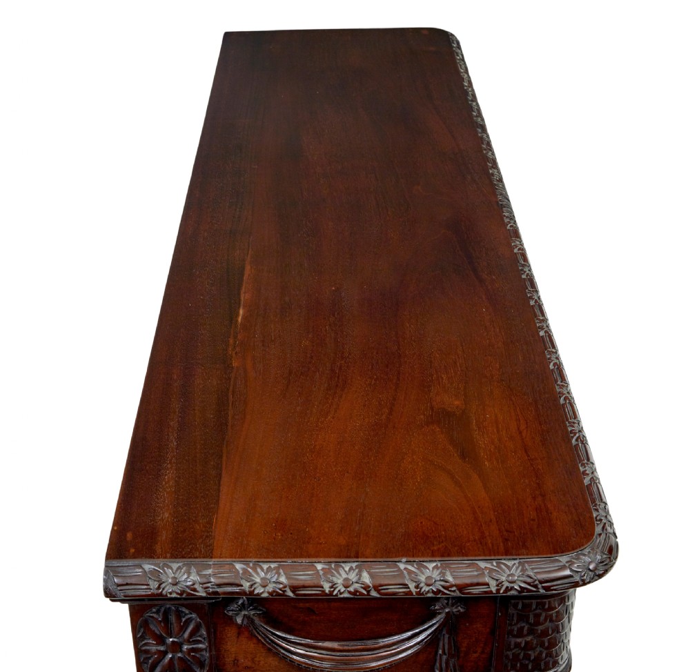A 19th-century dark mahogany console table featuring a carved central urn, drapery swags, and six slender fluted legs. View IX