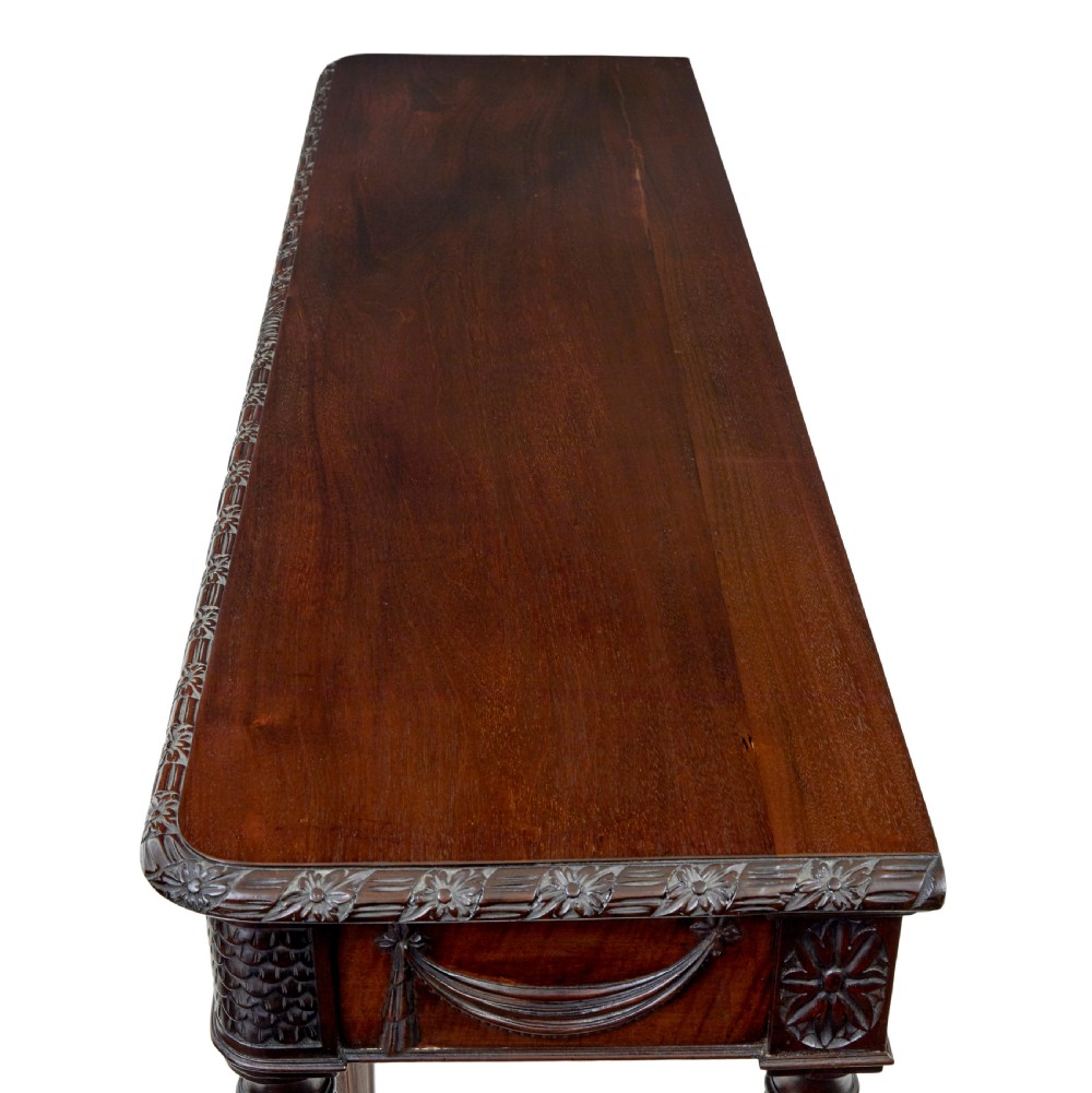 A 19th-century dark mahogany console table featuring a carved central urn, drapery swags, and six slender fluted legs. View X