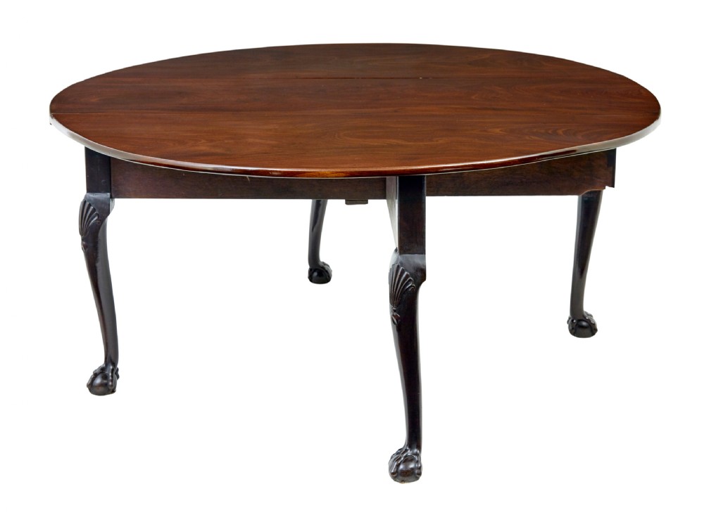 An eighteenth-century dark mahogany oval drop-leaf dining table featuring cabriole legs with carved knees and claw-and-ball feet. View IV