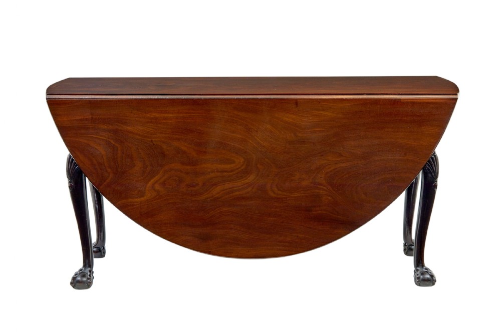 An eighteenth-century dark mahogany oval drop-leaf dining table featuring cabriole legs with carved knees and claw-and-ball feet. View VII