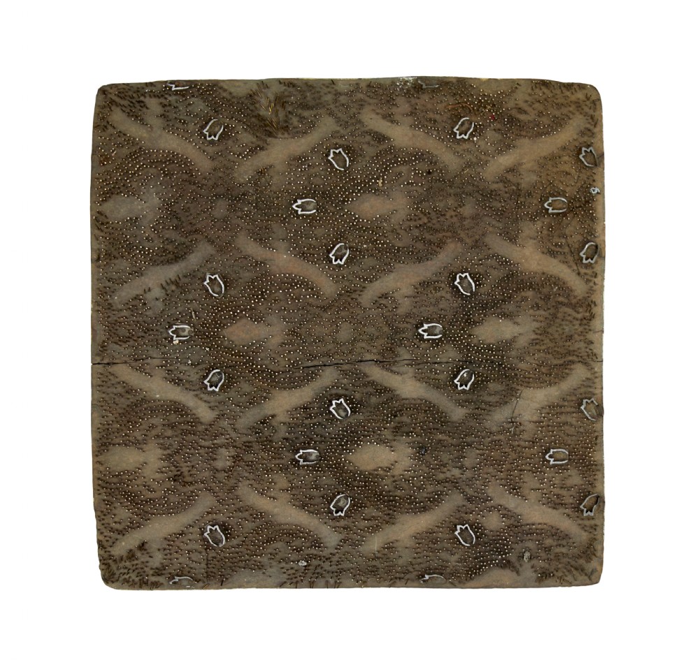 A collection of ten square and rectangular hand-carved wooden textile printing blocks featuring intricate brass wire and pin patterns. View V