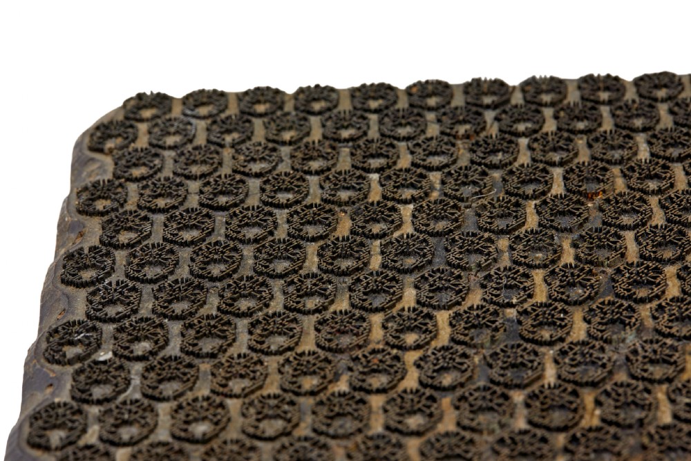 A collection of ten square and rectangular hand-carved wooden textile printing blocks featuring intricate brass wire and pin patterns. View XXI