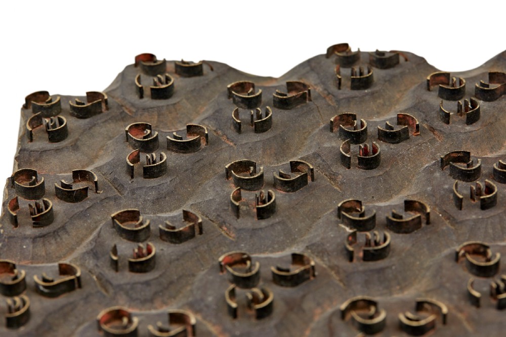 A collection of ten square and rectangular hand-carved wooden textile printing blocks featuring intricate brass wire and pin patterns. View XXII